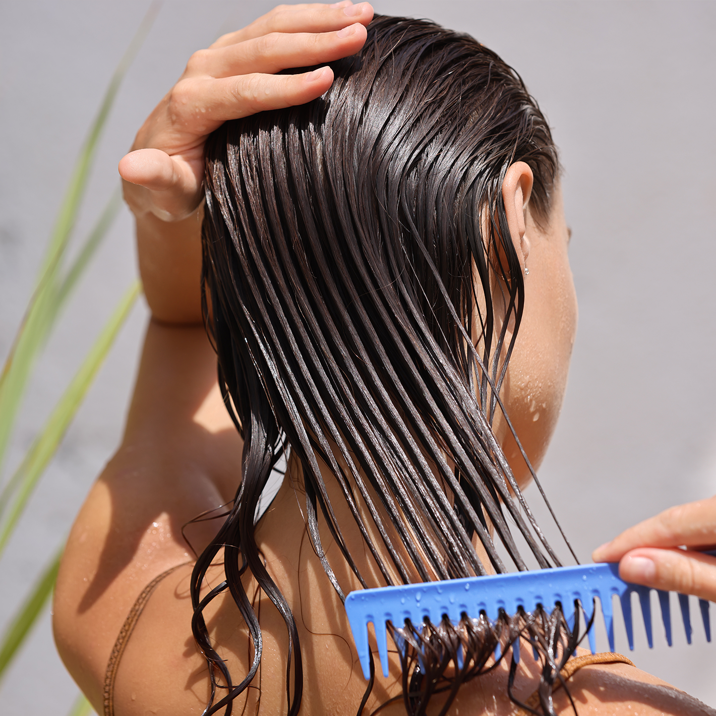 Woman combing her wet hair.