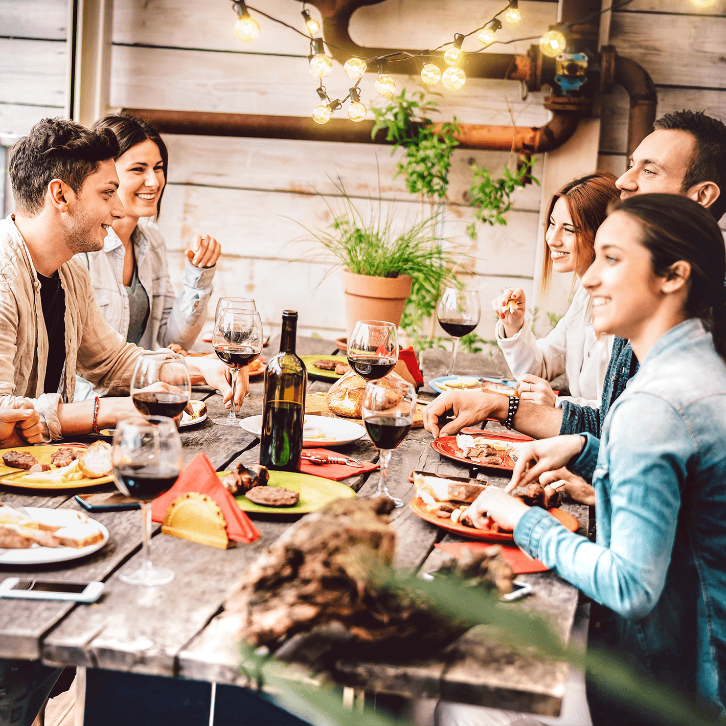 A group of people sitting around a wooden table eating dinner.