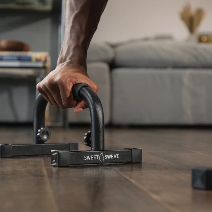 Close up of man using Sweet Sweat® push up bar.