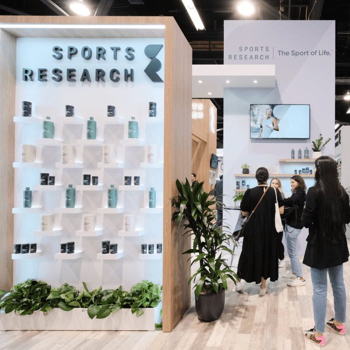 a group of people standing in front of a display of sports research.