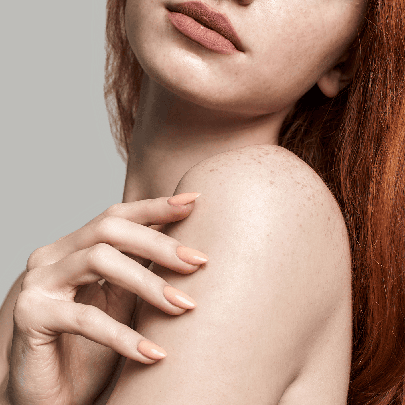 Woman looking over her shoulder with her well manicured hand on her shoulder.