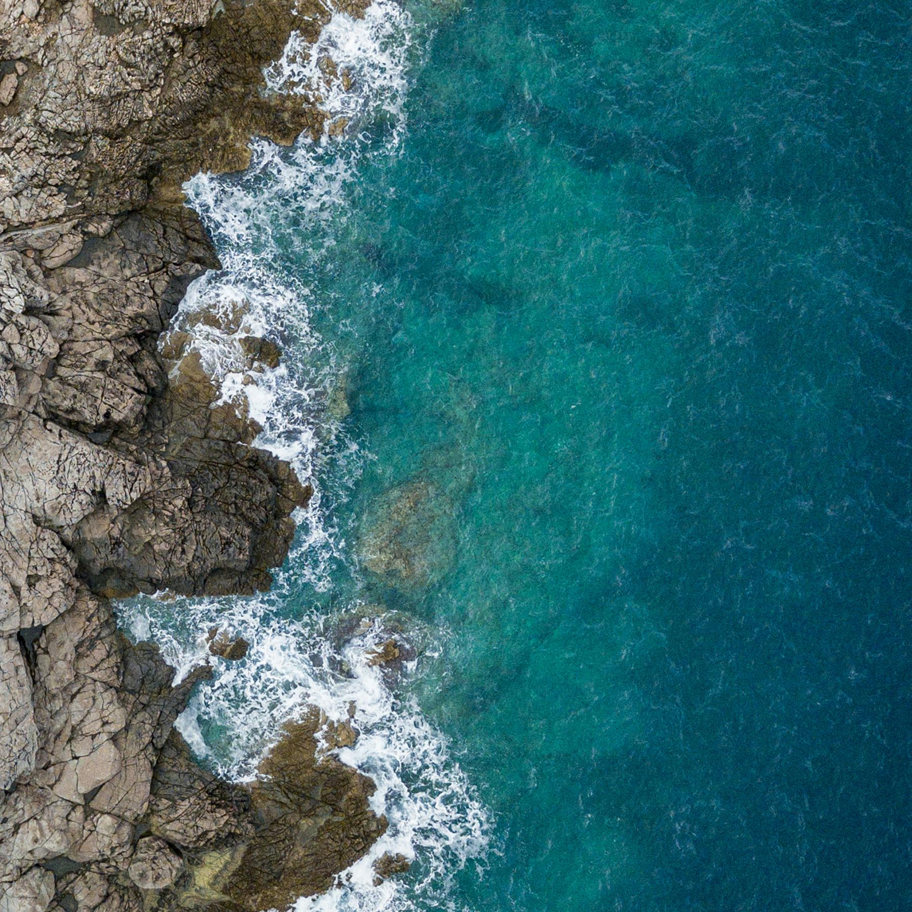 a bird's eye view of the ocean and rocks.
